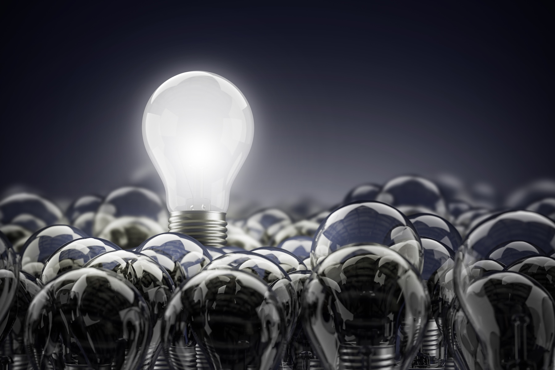 a lit lightbulb above unlit lightbulbs 
