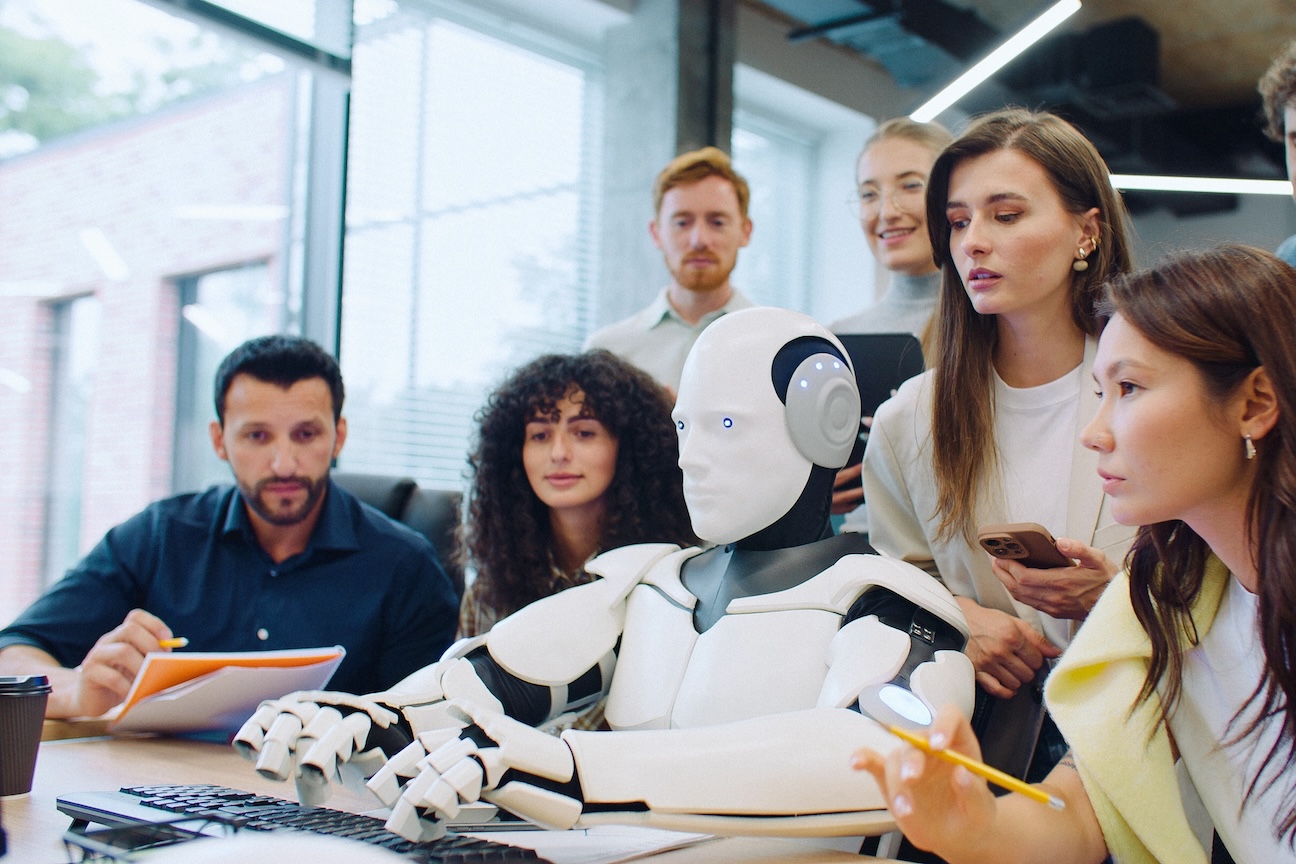 Office workers observing a robot at computer desk
