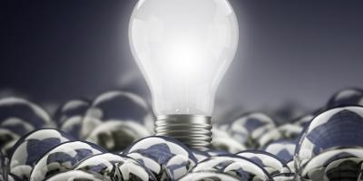 a lit lightbulb above unlit lightbulbs 
