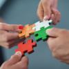 hands assembling puzzle