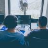 Two people participating in a code review, photo by Alvaro Reyes