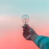 Hand holding up a light bulb