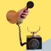 Hand holding black rotary telephone