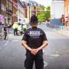 A police officer stands on a street with his back to the camera