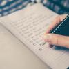 Person writing down rules for software testing in a notebook