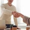 Tester and developer shaking hands across a table
