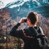 Man looking at mountains through binoculars