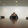 frustrated man sitting alone at conference table