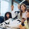 Office workers observing a robot at computer desk